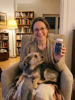 Frau mit Hund im Sessel, hält die Dose
